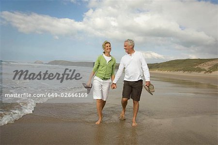 Couple walking hand in hand on a beach