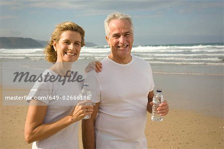 Couple drinking water on a beach