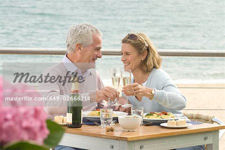Paar, das Essen im Restaurant am Meer