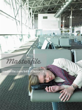 femme allongée sur le banc de l'aéroport