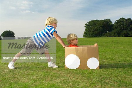boys pushing another boy in box