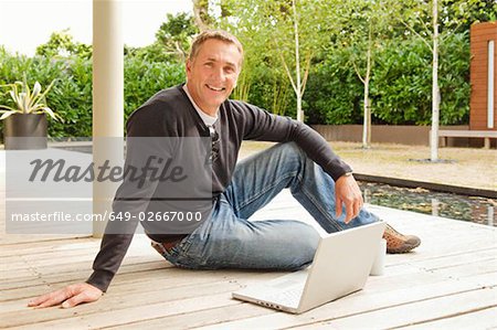 Businessman sitting outside smiling