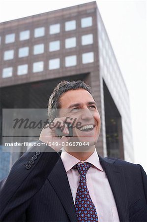 Business man using mobile phone outside