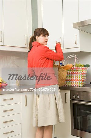 Woman in Kitchen with Shopping Bags
