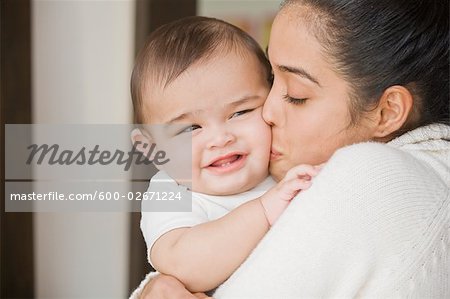 Mutter küssen Baby auf Wange