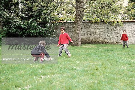 Boys playing with ball in yard