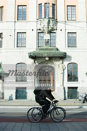 Schweden, Stockholm, Radfahrer Reiten vorbei an reich verzierten Gebäude