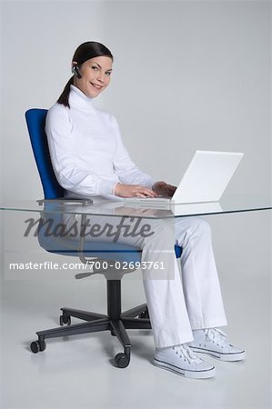 Femme assise au comptoir à l'aide d'ordinateur portable