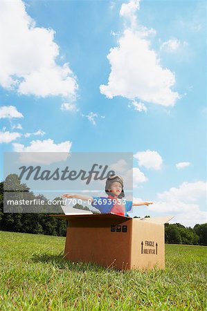 Boy Playing in Cardboard Box