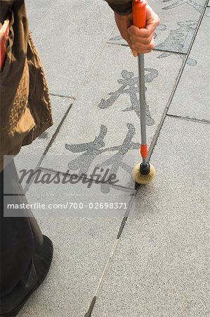 Homme pratiquant la calligraphie de l'eau sur la chaussée, Beijing, Chine