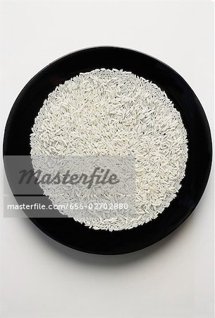 ungekochte Körner Reis ausgebreitet auf einer schwarzen Platte