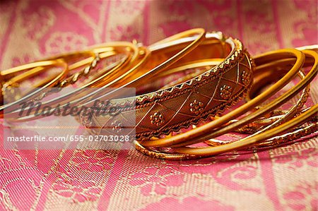 gold Indian bangles on pink sari cloth