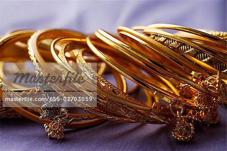 Gold indische Armreifen auf lila Sari-Stoff