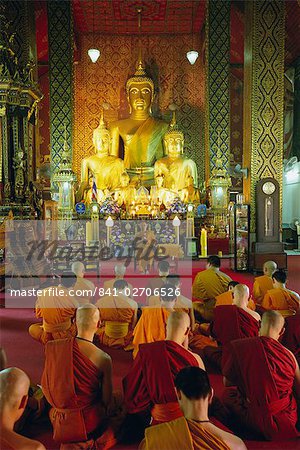 Moines assis à l'intérieur du temple, le Wat Phra que Haripunchai, Lamphun, Thaïlande du Nord, Asie