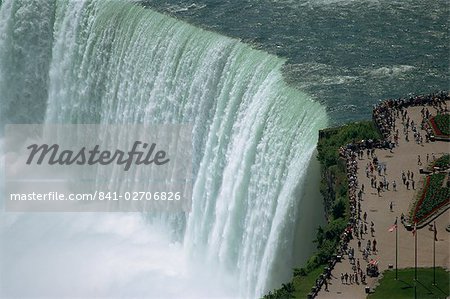 Tourists on viewing platform on Canadian side of the waterfall view the Horseshoe Falls at Niagara, Ontario, Canada, North America
