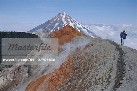 Koryaksky volcano seen beyond walkers on crater rim of Avacha volcano, Kamchatka, East Siberia, Russia Koryaksky volcano seen beyond walkers on crater rim of Avacha volcano, Kamchatka, East Siberia, Russia