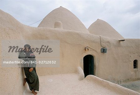 Jinar, 15 year old girl in front of a 200 year old beehive house in the desert, Ebla area, Syria, Middle East