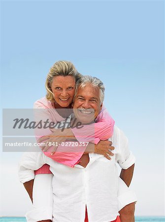 senior couple on beach hugging