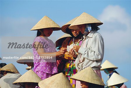 Women in conical hats counting money at the fish market by the Thu Bon River in Hoi An, south of Danang, Vietnam, Indochina, Asia