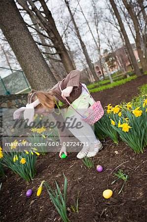 Petite fille à la recherche d'oeufs de Pâques
