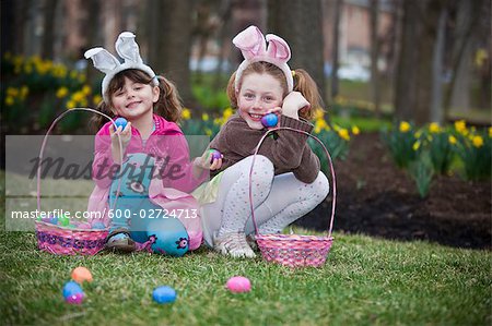 Deux jeunes filles qui posent maintenant des oeufs de Pâques