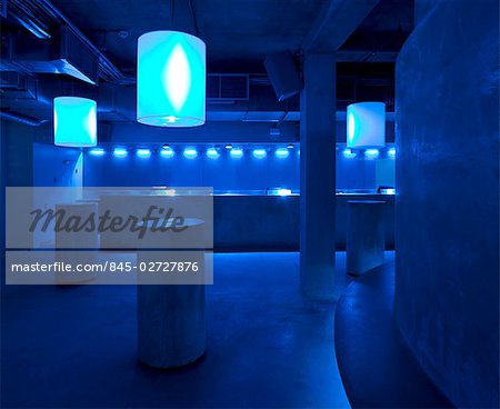 Matter, The O2, Peninsula Square, London.  drum tables of concrete and bar with blue lights. Architect: William Russell - Pentagram.