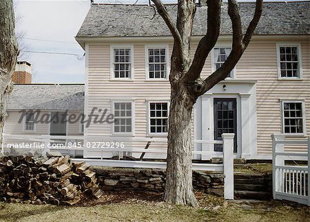 Late 18th -early 19thc timber frame clapboard farmhouse in winter, logpile of firewood, Lyme, Connecticut