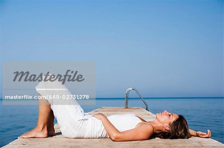 Woman laying on a pier