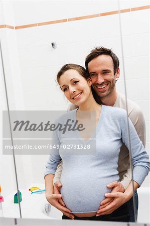 Femme enceinte et l'homme regardant dans le miroir