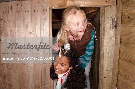 Two young girls inspect treehouse