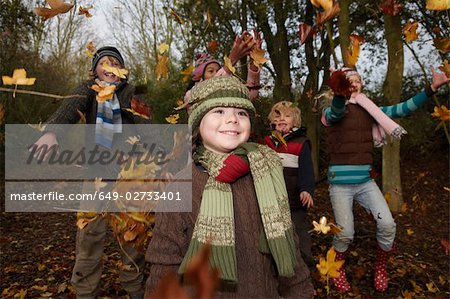 Enfants jetant les feuilles d'automne