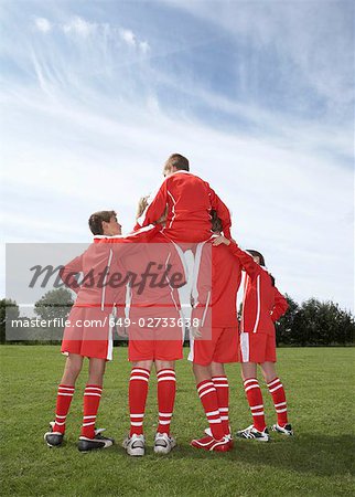 Sitzend auf einem Mannschaften Schultern Fußballspieler