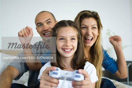 Fille jouant des jeux vidéo, regarder et applaudir les parents