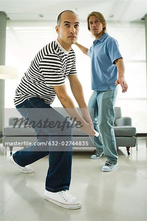 Two men playing video game with wireless controllers