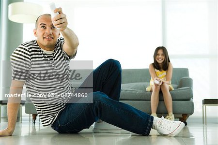 Père et fille jouer jeu vidéo avec les contrôleurs sans fil