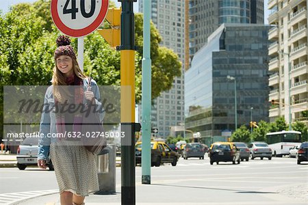 Trendy young woman walking along city street