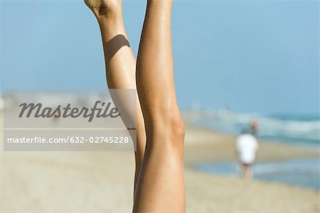 Frau Beine in der Luft, Strand im Hintergrund