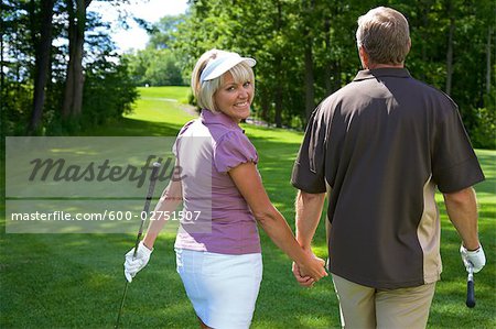 Backview of Couple Walking on Golf Course