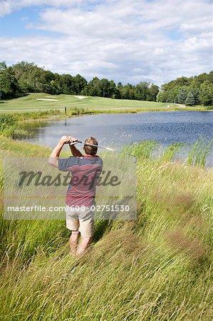 Vue arrière du Man, jouer au golf dans les hautes herbes