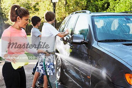 Woman and Teenage Sons Washing Car