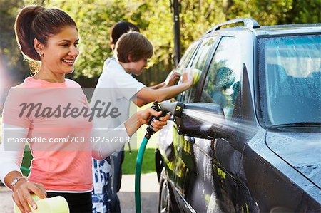 Woman and Teenage Sons Washing Car