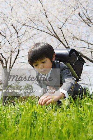 Lycéen japonais tenant le sac et la plumaison herbe