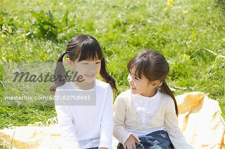 Japanese girls sitting in a garden