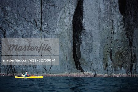 Person Boating on Kayak Near Cliff, Hokkaido, Japan