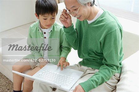 Grandson showing laptop to grandfather