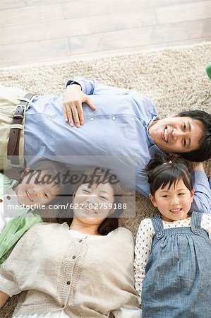 Japanese family lying down on carpet