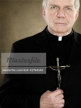 Ein Priester hält einen Kruzifix