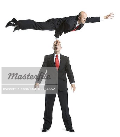 Zwei männliche Akrobaten in Anzügen durchführen