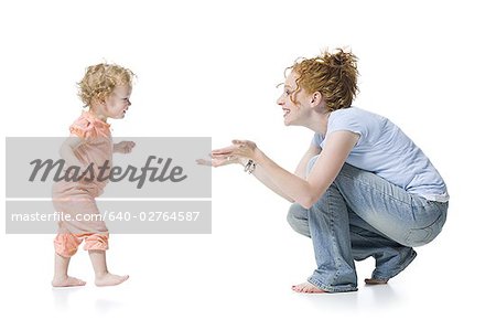 Profile of a baby girl reaching for her mother