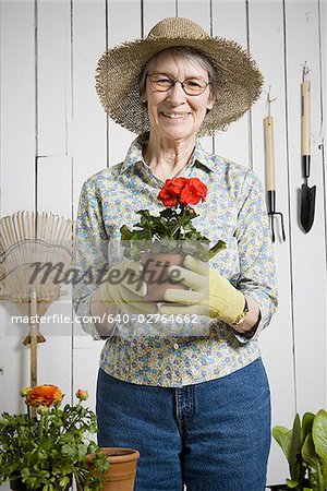 Portrait of an elderly woman holding a potted plant